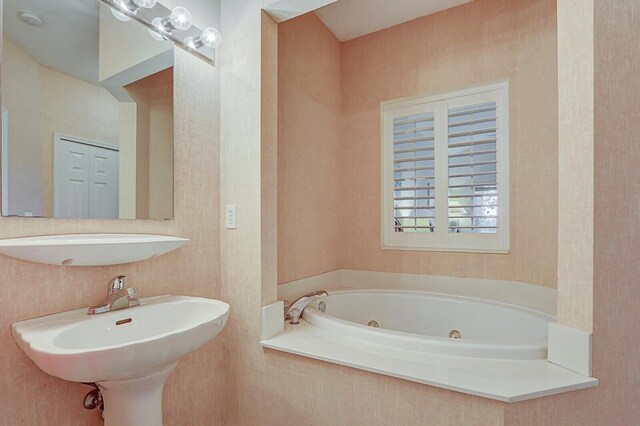 bathroom with a washtub and sink