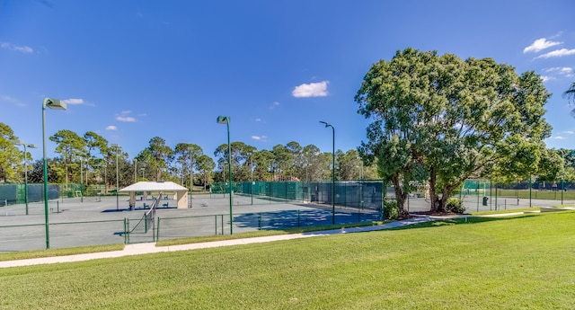 view of tennis court with a yard