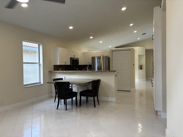 dining space featuring lofted ceiling and light tile patterned flooring