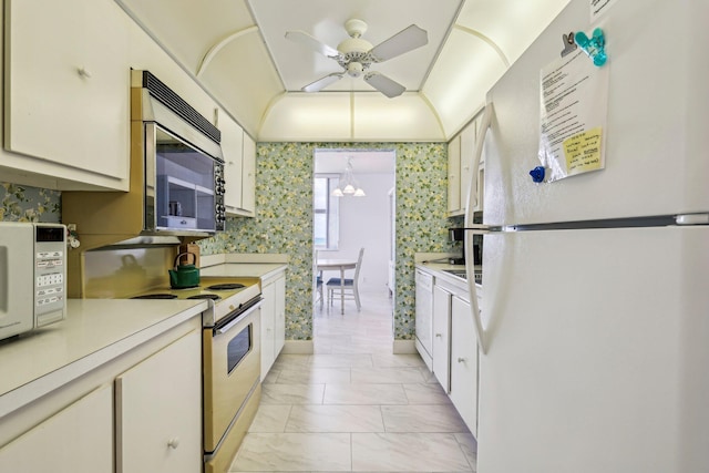 kitchen with white cabinetry, white appliances, and ceiling fan with notable chandelier