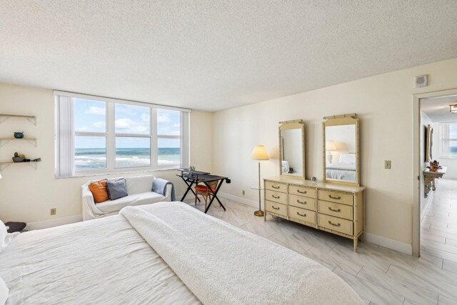 bedroom featuring a textured ceiling and a water view