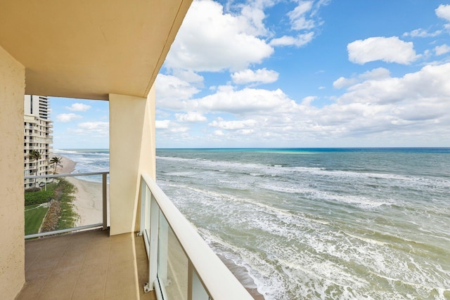 balcony featuring a view of the beach and a water view