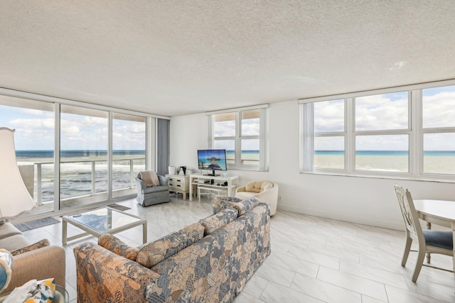 living room with a water view and a textured ceiling