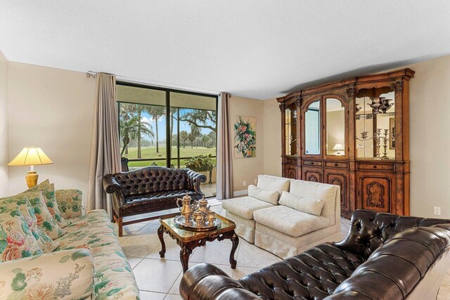 tiled living room featuring an inviting chandelier and a textured ceiling