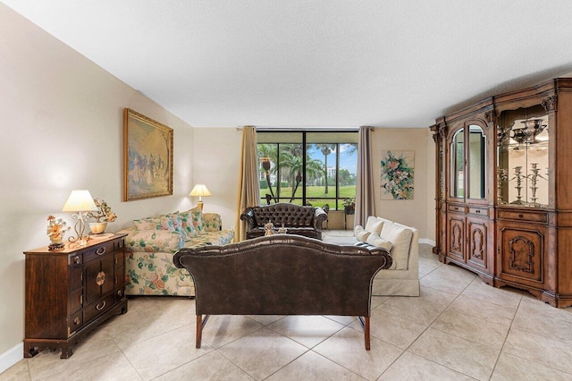 living area featuring light tile patterned floors, baseboards, and a textured ceiling
