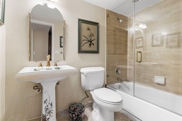 full bath with toilet, bath / shower combo with glass door, and baseboards