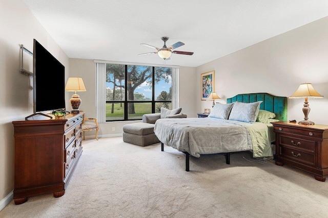 bedroom featuring ceiling fan, light carpet, and baseboards