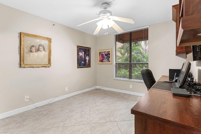 home office with light tile patterned floors, baseboards, ceiling fan, and a textured ceiling