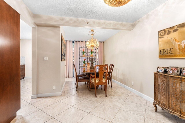 tiled dining space featuring a notable chandelier and a textured ceiling