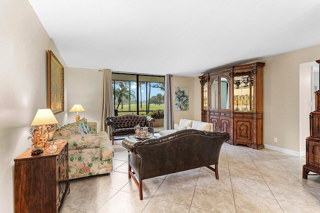 living area with baseboards and light tile patterned floors