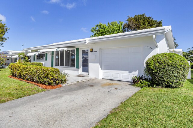 ranch-style home with a garage and a front lawn