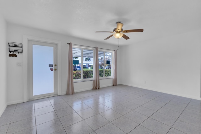 tiled spare room featuring ceiling fan