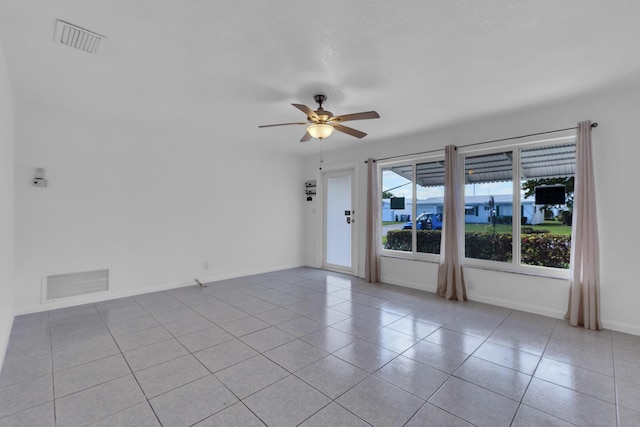 tiled spare room featuring ceiling fan