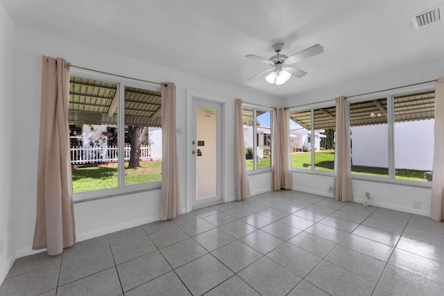 empty room with ceiling fan and light tile patterned floors