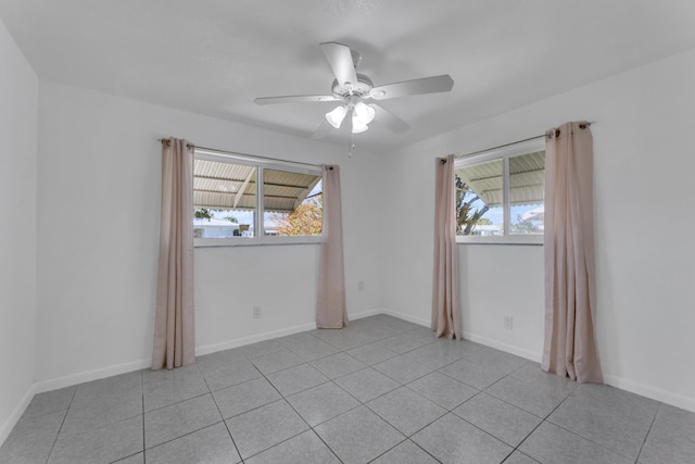 tiled empty room featuring plenty of natural light and ceiling fan