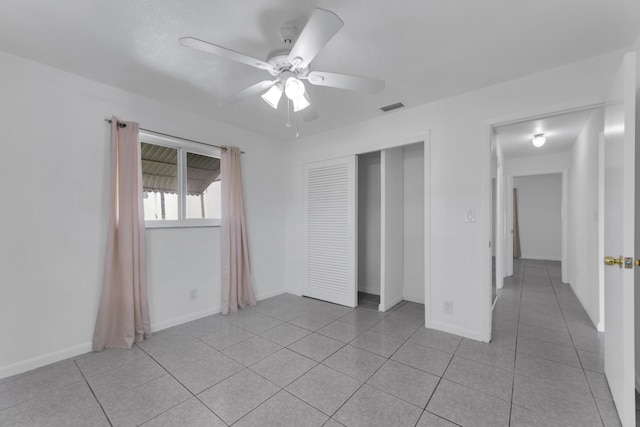 unfurnished bedroom with ceiling fan, a closet, and light tile patterned floors