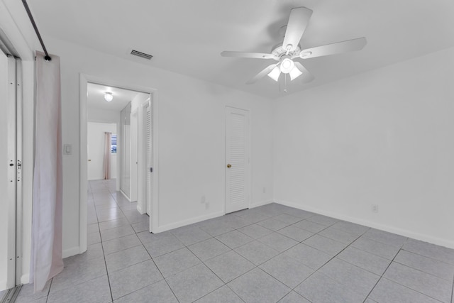 empty room featuring ceiling fan and light tile patterned flooring