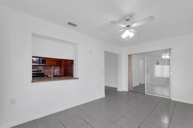 spare room with sink, tile patterned floors, and ceiling fan