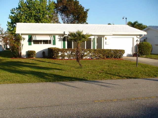 ranch-style home with a garage and a front lawn