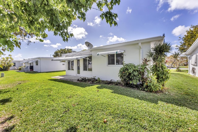 rear view of property featuring a lawn