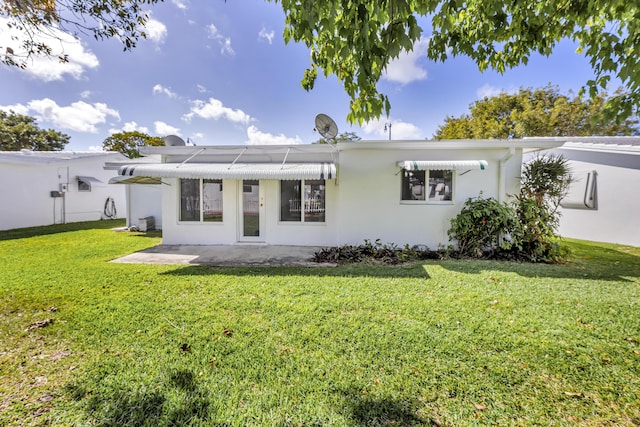 rear view of property with a yard and a patio area