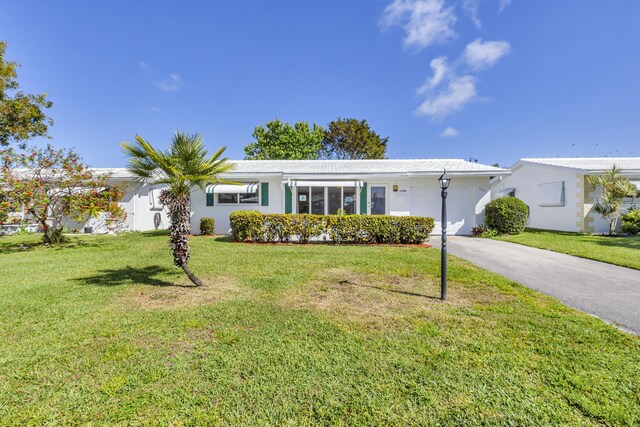 single story home featuring a garage and a front yard