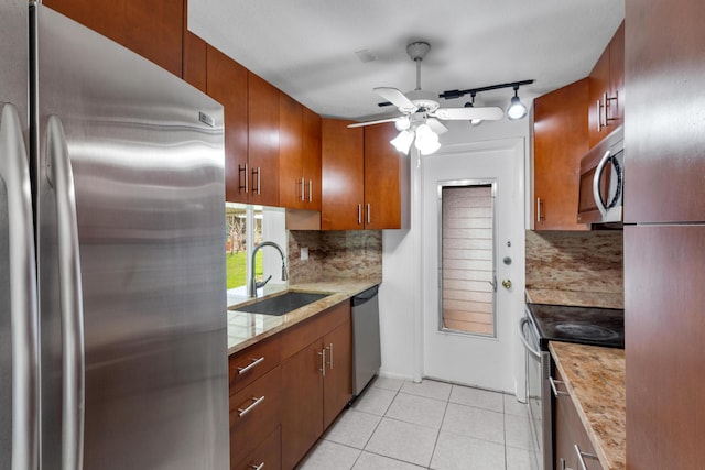 kitchen featuring appliances with stainless steel finishes, tasteful backsplash, sink, light tile patterned floors, and ceiling fan