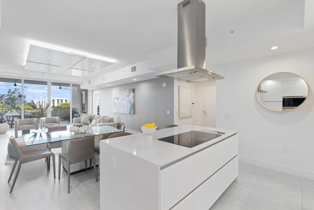 kitchen with baseboards, white cabinets, modern cabinets, island exhaust hood, and black electric cooktop