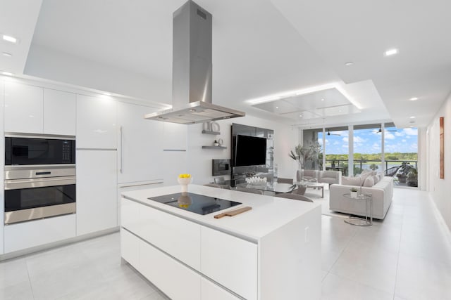 kitchen featuring island range hood, white cabinetry, floor to ceiling windows, black appliances, and modern cabinets