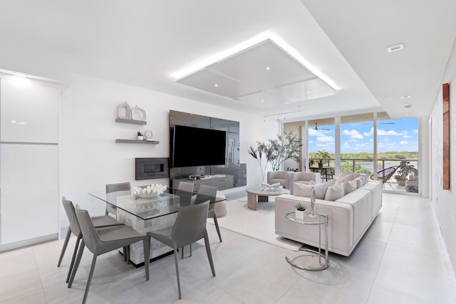 living room with light tile patterned floors and a wall of windows