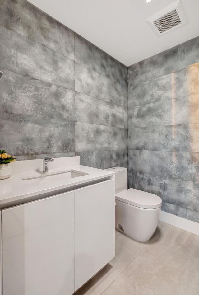 bathroom with toilet, visible vents, and vanity