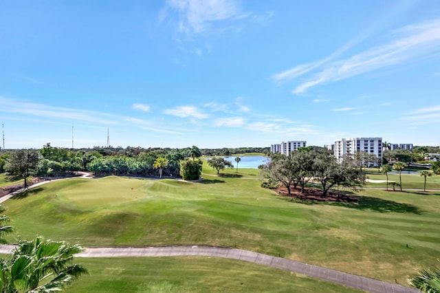 view of property's community featuring view of golf course, a lawn, and a water view