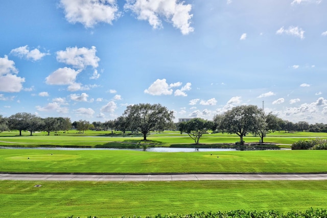 view of home's community with a water view, golf course view, and a lawn