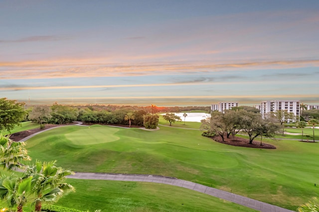 surrounding community featuring a water view, a lawn, and golf course view