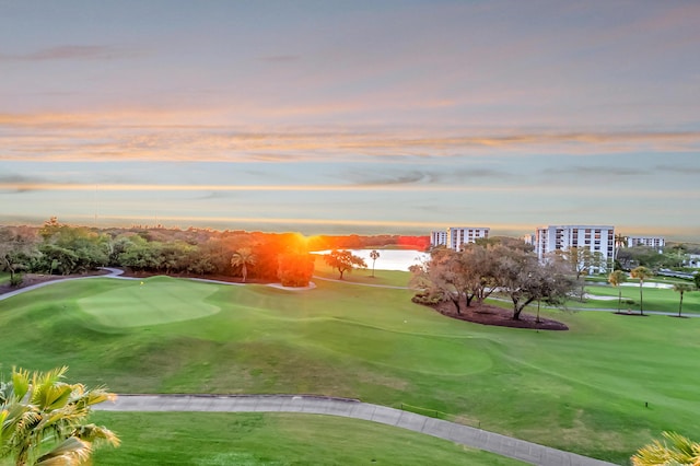 view of property's community with view of golf course and a lawn