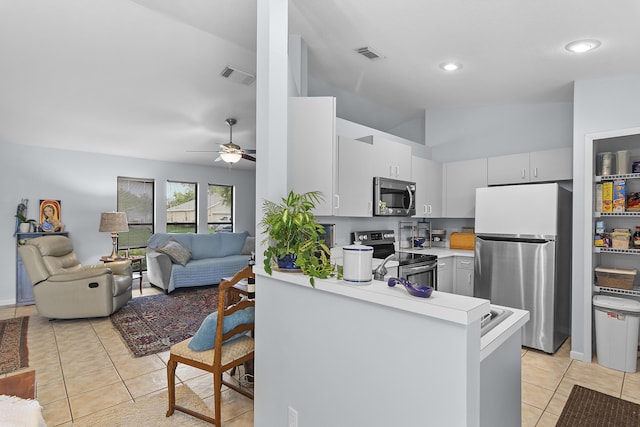 kitchen featuring kitchen peninsula, light tile patterned floors, lofted ceiling, and stainless steel appliances