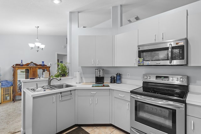 kitchen with kitchen peninsula, hanging light fixtures, white cabinetry, light tile patterned floors, and stainless steel appliances