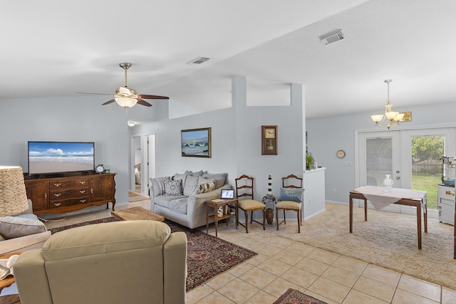 living room with french doors, ceiling fan with notable chandelier, light tile patterned floors, and lofted ceiling