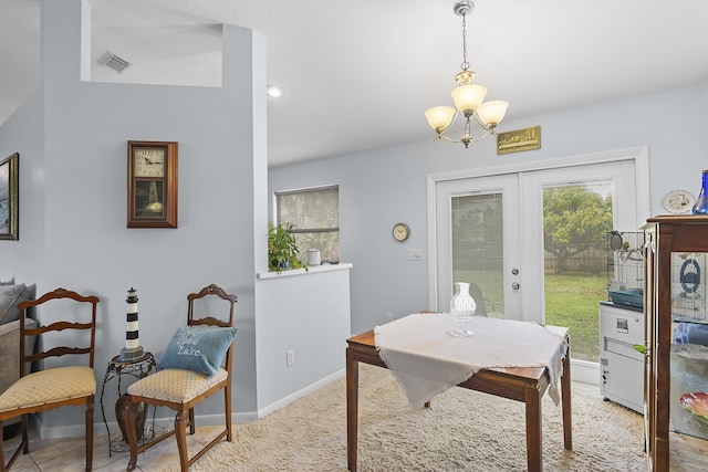 dining space featuring french doors and an inviting chandelier