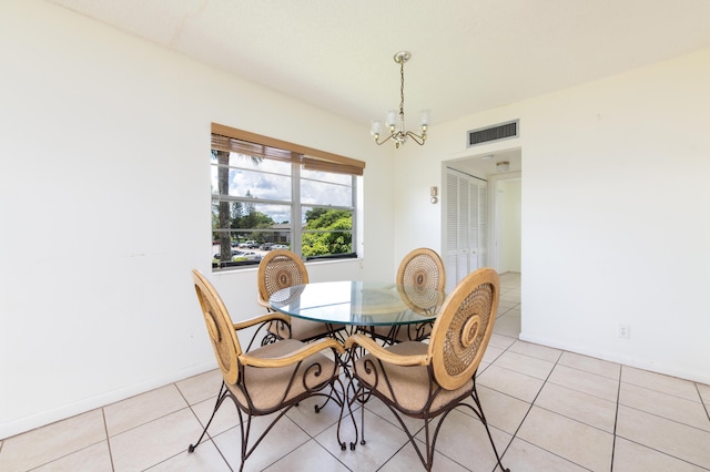 tiled dining room with a chandelier