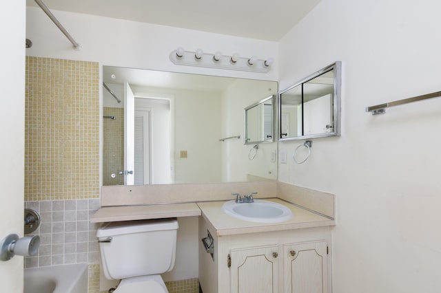 full bathroom with vanity, tiled shower / bath combo, and toilet