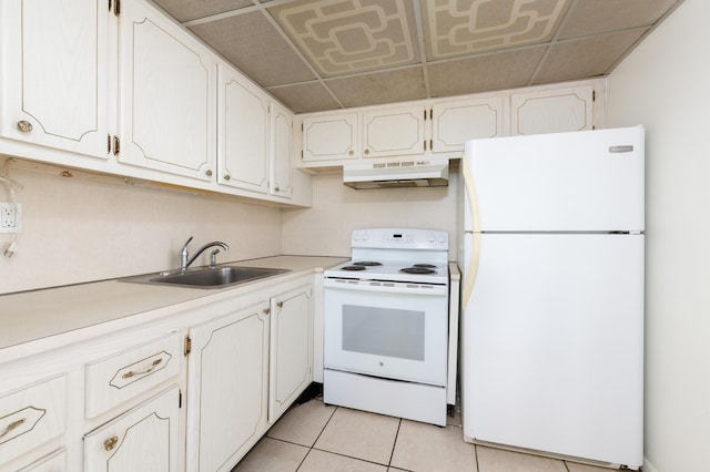 kitchen with sink, a paneled ceiling, light tile patterned floors, white appliances, and white cabinets