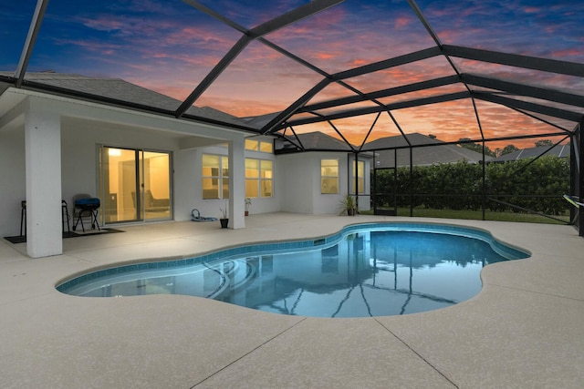 pool at dusk with a lanai and a patio