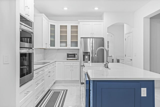 kitchen with sink, white cabinetry, and a center island with sink