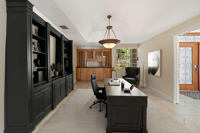 tiled office space with a tray ceiling