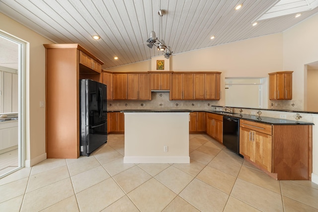 kitchen featuring decorative light fixtures, lofted ceiling with skylight, black appliances, and light tile patterned flooring