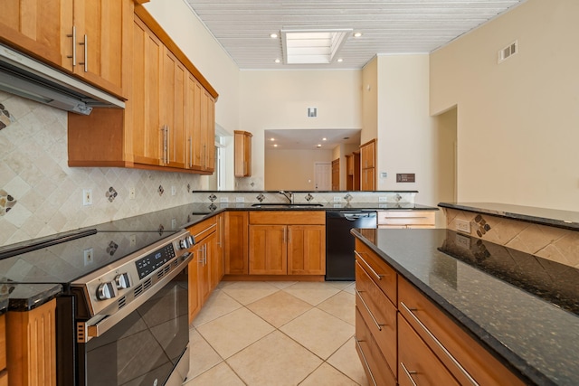 kitchen with dishwasher, sink, dark stone countertops, stainless steel range with electric cooktop, and light tile patterned floors