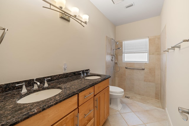 bathroom featuring tiled shower, vanity, toilet, and tile patterned floors