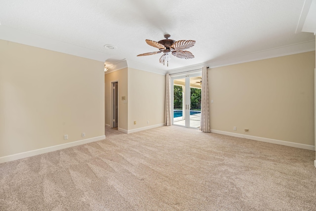 carpeted spare room featuring ceiling fan, ornamental molding, and a textured ceiling