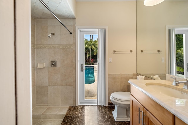 bathroom with vanity, a wealth of natural light, tile walls, and toilet